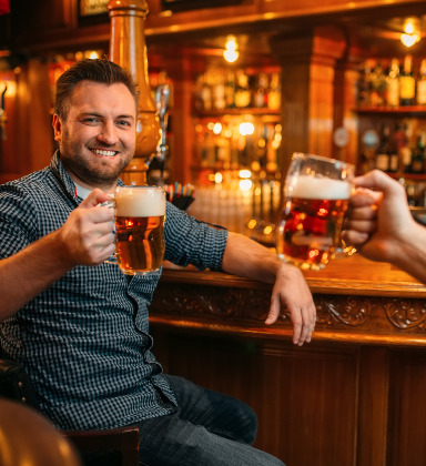 Man cheerings beer in mug - bar and nightclub age verification platform
