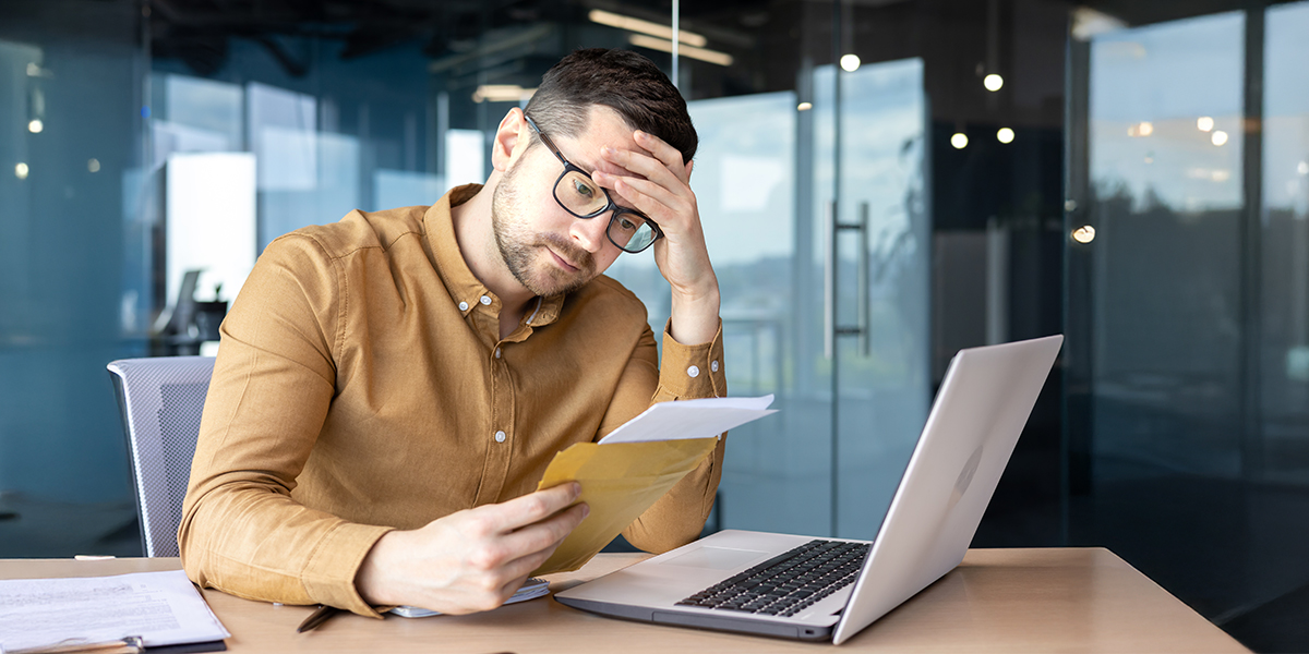 Fines Or Distressed Business Owner Reading Legal Document